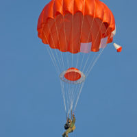 man descends under red HX-Series canopy