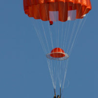 man descends under red HX-Series canopy