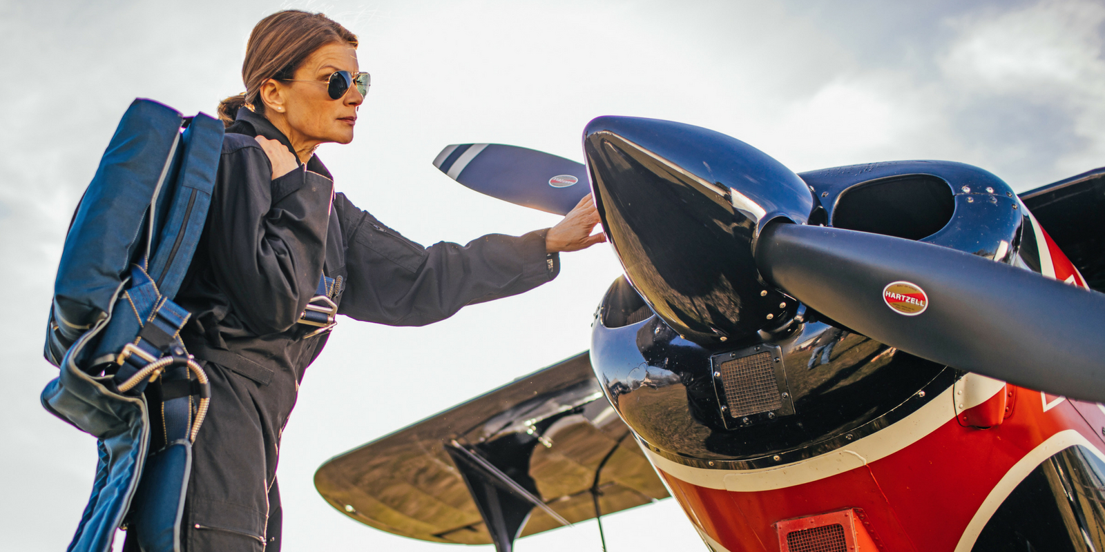 woman with vintage aircraft wearing blue Butler seat parachute